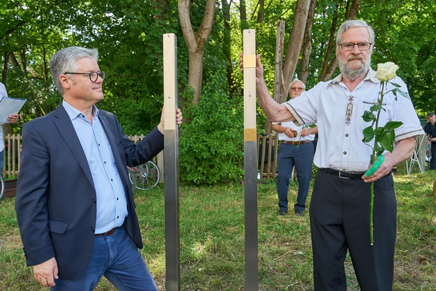 Mitglieder der Siedlervereinigung bringen ein Erinnerungszeichen an