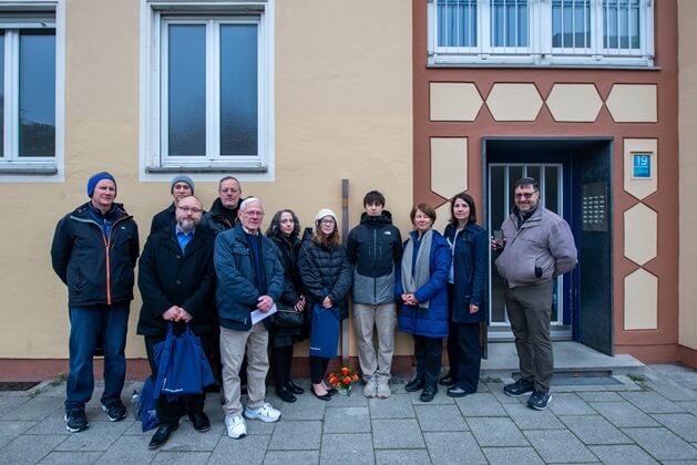 Angehörige neben dem Erinnerungszeichen für Malwine Porsche