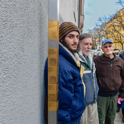 Bruce Neuburger, Rick Shulein und Elijah Labowe-Stoll neben den Erinnerungszeichen für die Familien Holzer und Spatz
