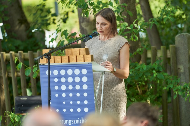Mitglieder der Siedlervereinigung verlesen die Biografien