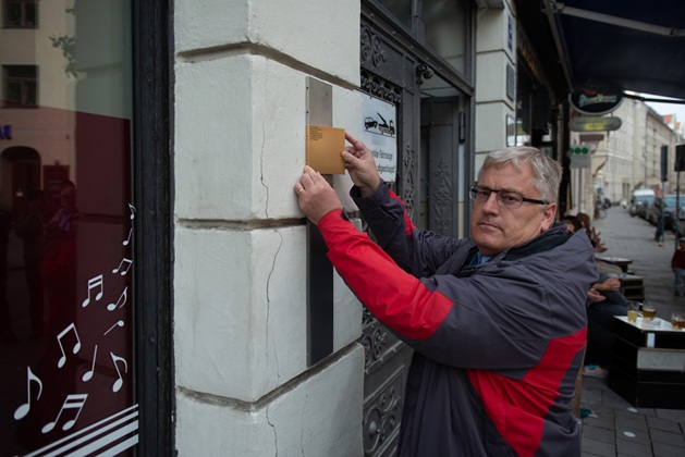 Stefan Dickas, Erinnerungswerkstatt München e.V., bringt das Erinnerungszeichen für Max Ursprung an