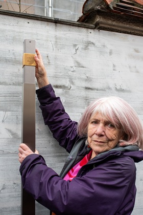 Merilyn Moos installs the Memorial Sign