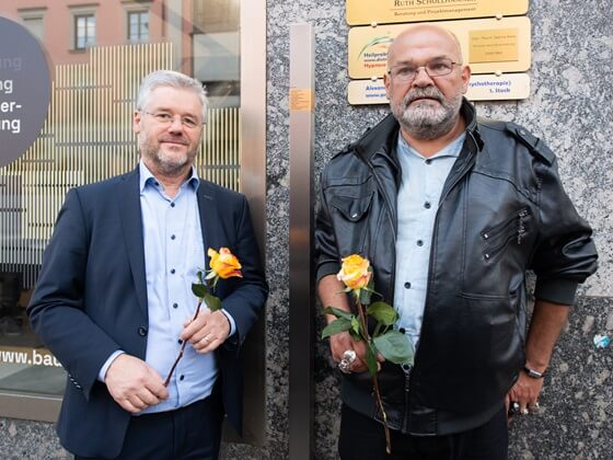 Stadtrat Winfried Kaum und Arnold Schuster vor dem Erinnerungszeichen für Hedwig Schuster