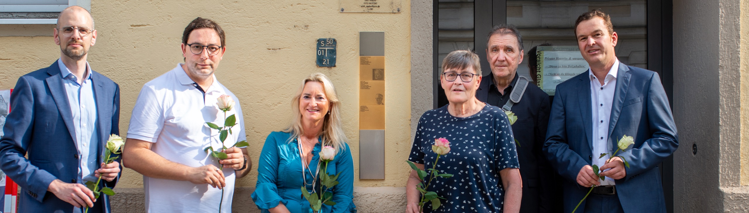 Gruppenbild vor den Erinnerungszeichen für Siegmund Hellmann, Julie Weinmann und Carry Brachvogel