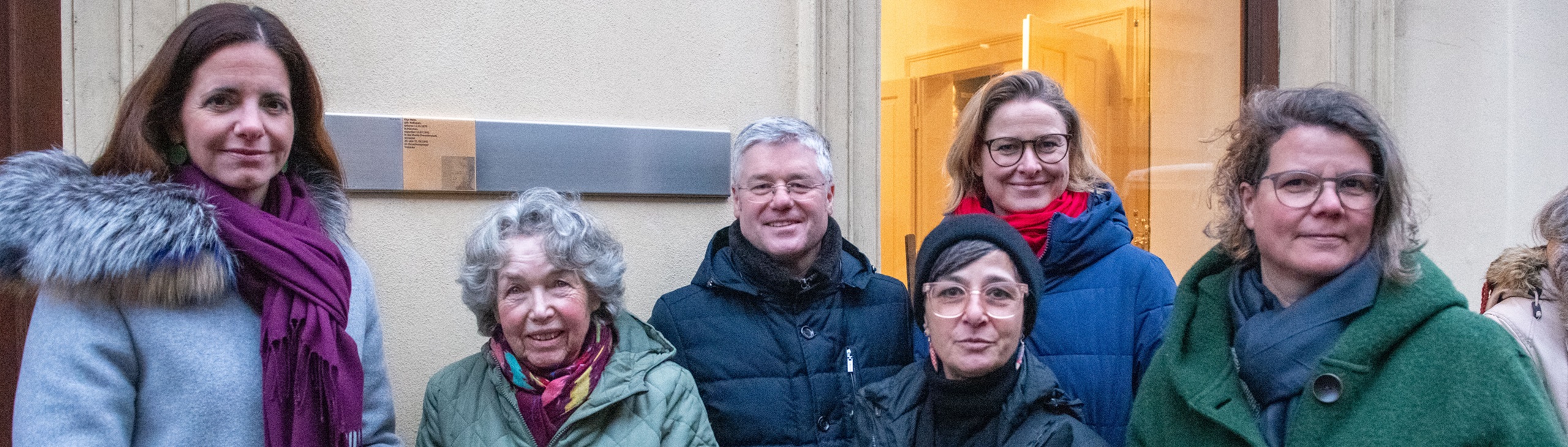 Relatives standing by the Memorial Sign for Olga Maier