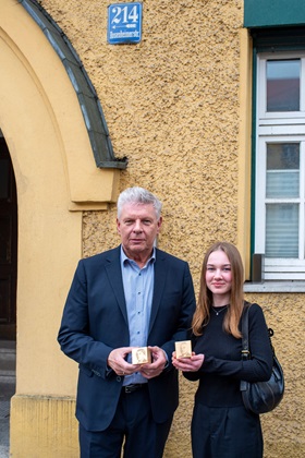 Oberbürgermeister Dieter Reiter und eine Schülerin zeigen die Erinnerungszeichen für Julie und Ludwig Löwenthal