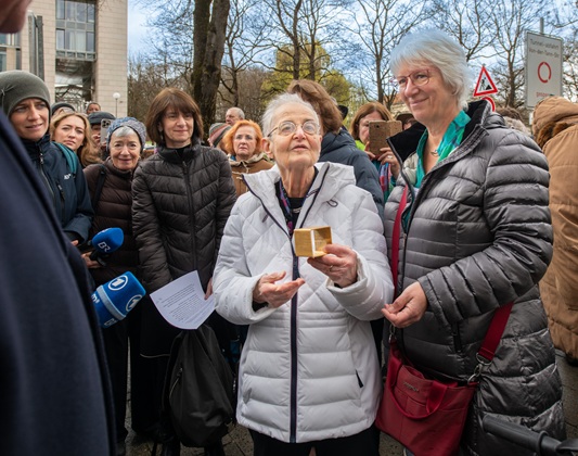 Anna Maria Abernathy shows the Memorial Sign for Minna Hirschberg