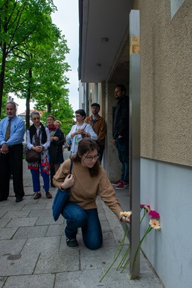 A relative leaves flowers at the Memorial Signs for Emma and Jakob Springer