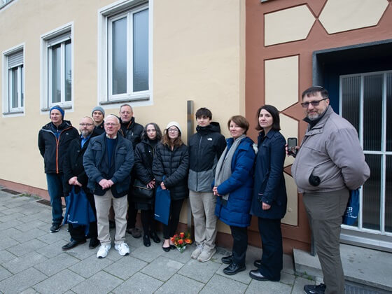 Familienangehörige neben dem Erinnerungszeichen für Malwine Porsche