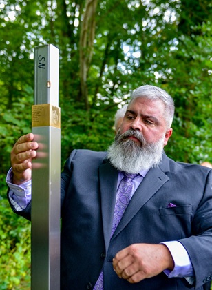 James Patrick Greene, Angehöriger,  bringt das Erinnerungszeichen für Staff Sergeant James M. Greene an