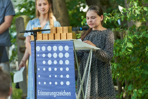 Mitglieder der Siedlervereinigung verlesen die Biografien