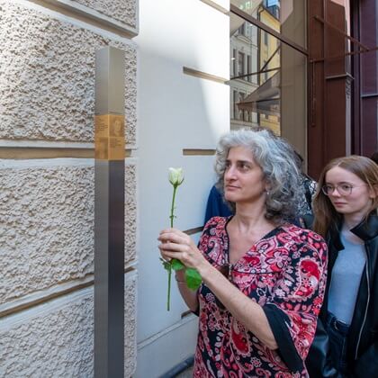 A relative next to the Memorial Sign for Emanuel and Rosa Reis