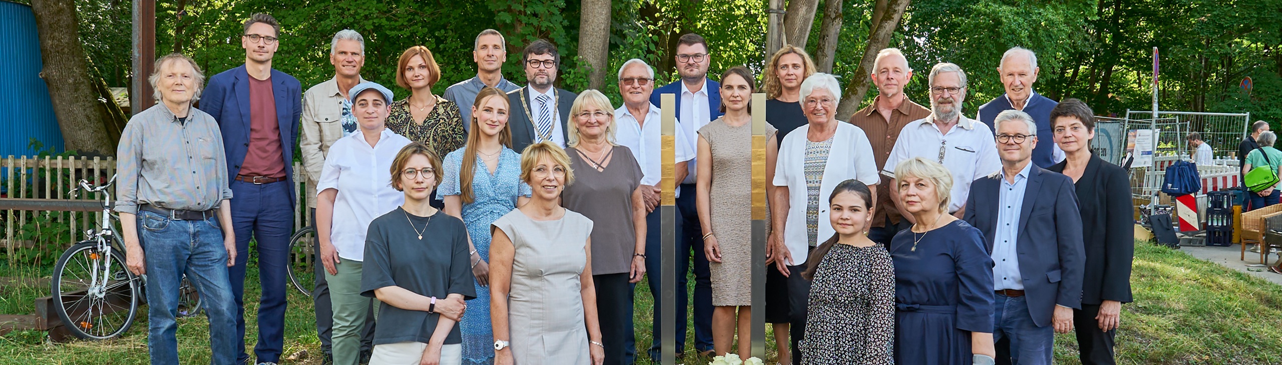Gruppenbild mit den Erinnerungszeichen für die Zwangsarbeiter in Neuaubing