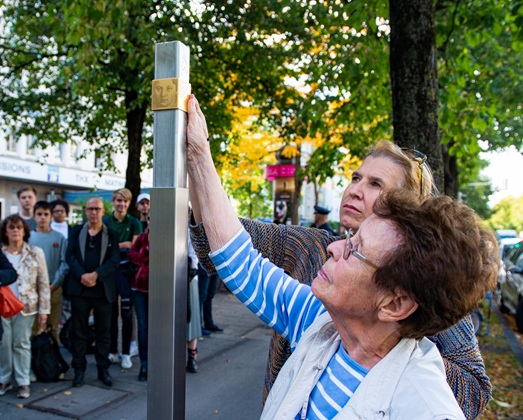 Edith Roemer, relative, installs the Memorial Signs