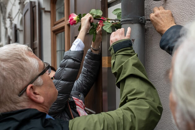 Gäste legen Blumen auf das Erinnerungszeichen für Walter Häbich