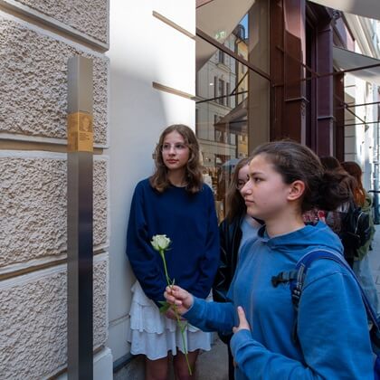 Angehörige vor den Erinnerungszeichen für Emanuel und Rosa Reis