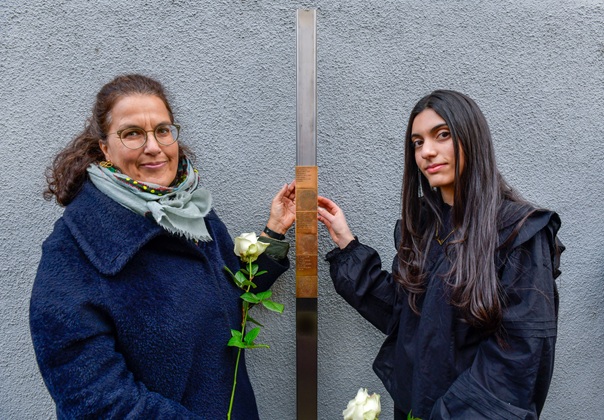 Katharina Willimski und eine Schülerin bringen das Erinnerungszeichen für Martha Babette Holzer an