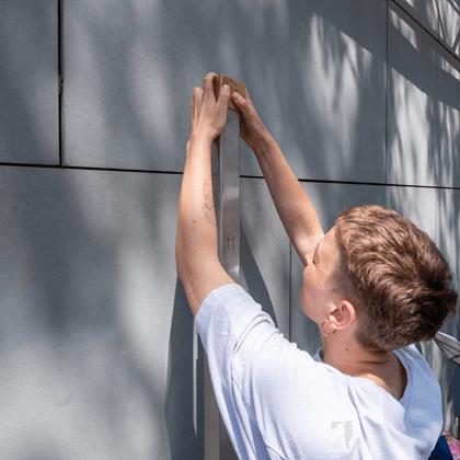 A relative installing the Memorial Sign for Joseph Weiss